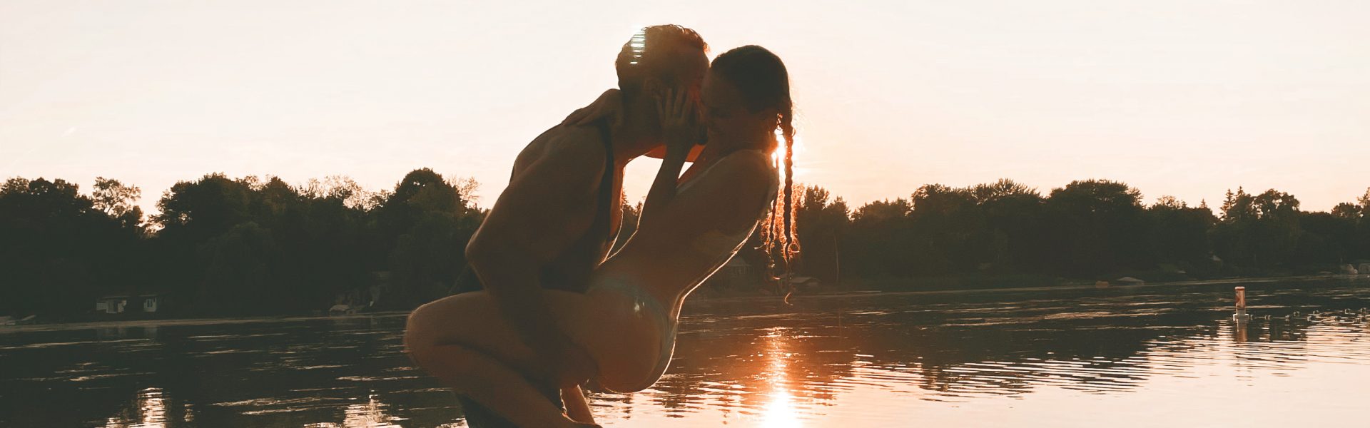 couple at the beach during sunset, wrapped in each other's arms