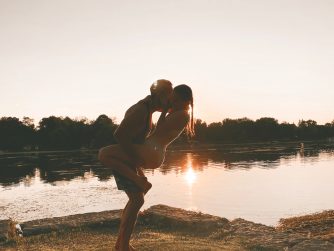 couple at the beach during sunset, wrapped in each other's arms