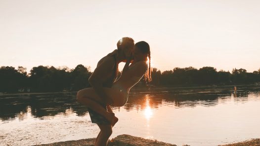 couple at the beach during sunset, wrapped in each other's arms